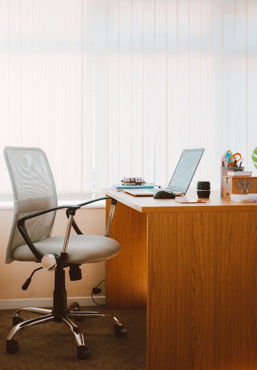 A tranquil modern home office featuring a wooden desk, ergonomic chair, and soft natural light.