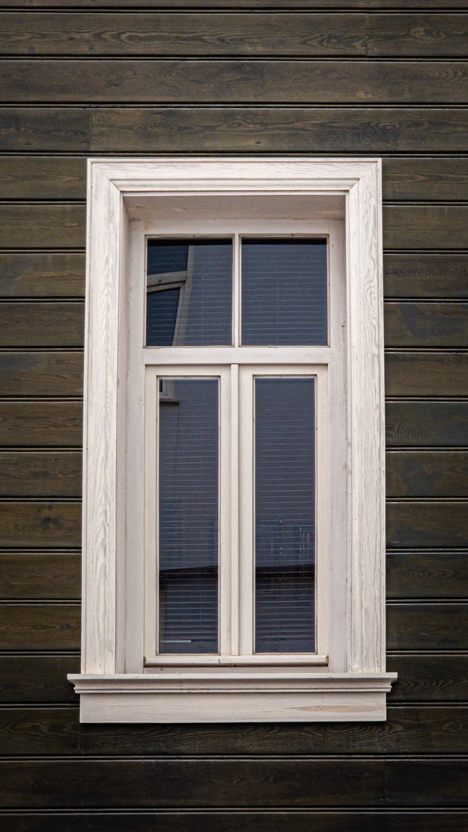 Elegant vintage wooden window on a rustic wooden building exterior, showcasing classic architectural design.